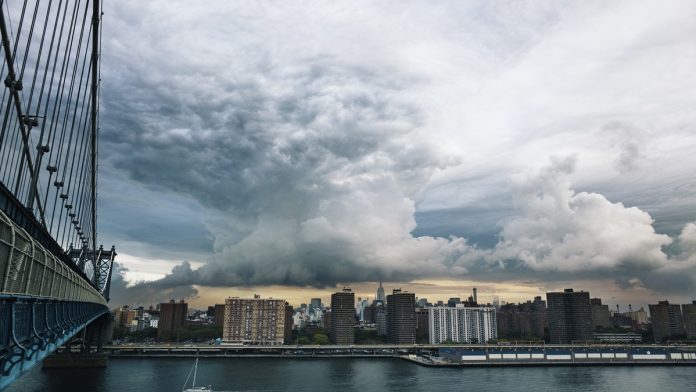 Manhattan Bridge Over East River Against Cloudy Sky